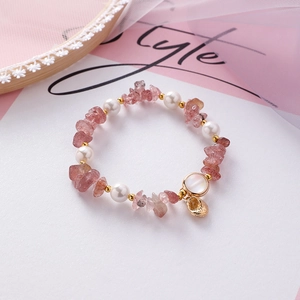 Macro detail of pink strawberry quartz and white pearls on a romantic beaded bracelet
