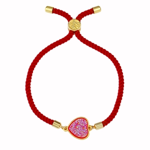 Detalle de pulsera de cuerda roja trenzada con dije de corazón dorado e incrustación Druzy
