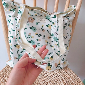 Detailed macro shot of the vintage floral canvas bag with cotton strap and inner brand label