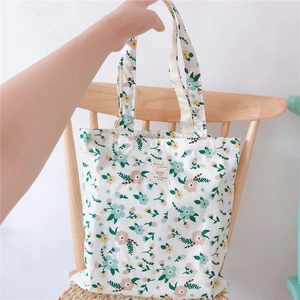 Detail of floral canvas tote bag with plant patterns on a wooden chair