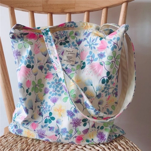 Detail of floral canvas tote bag showing artistic plant pattern on a soft fabric texture
