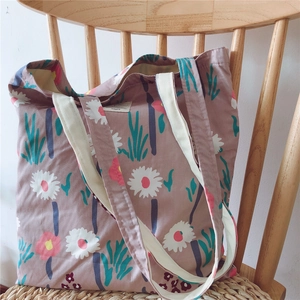 Detailed shot of floral cotton tote bag with daisy pattern on wooden chair
