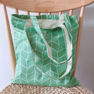 Detail of floral canvas tote bag with geometric pattern and sturdy handles on a chair