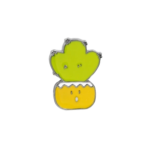 Close-up of a cute green cactus enamel pin in a yellow pot with silver metal edges