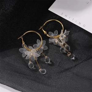 Golden flower hoop earrings with matte white petals and clear crystal teardrop pendants