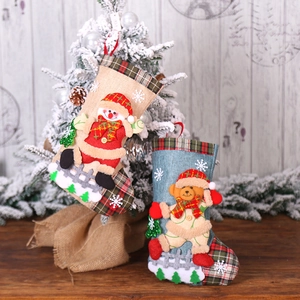 Chaussettes de Noël en toile de jute avec bonhomme de neige et ours sur table en bois