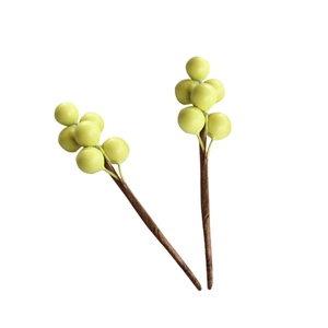Lifelike light yellow-green artificial berry stems for home decor on white background