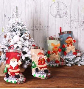 Détail de quatre chaussettes de Noël en toile de jute avec motifs 3D du Père Noël