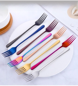 Polished long handle stainless steel forks in seven vibrant colors on a white plate