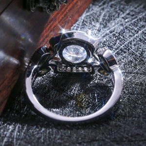 Macro shot of silver ring detailing intricate hollow setting and brilliant main stone