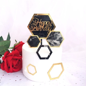 Detail of acrylic Happy Birthday cake topper with gold frame and black marble hexagon pattern