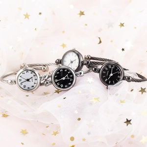 Variety of quartz bangle watches on white tulle fabric with golden star patterns