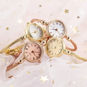 Close-up of gold and rose gold quartz cuff watches on soft pink tulle with stars
