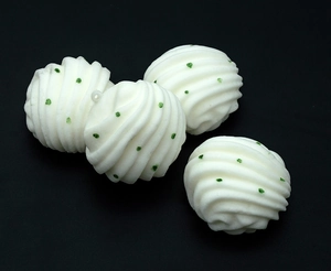 Detailed view of spiral texture and green glitter dots on white foam bun charms