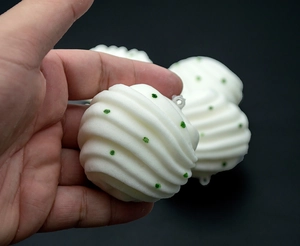 Macro shot of white spiral squishy bun toy with green glitter detail for keychains