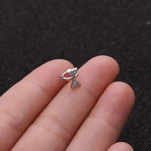 Macro shot of a silver bow-shaped huggie earring with micro-set cubic zirconia crystals