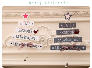 Detail view of wooden Christmas tree door hanging with red bird, bow and bell decor