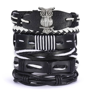 Detail of multi-layer leather bracelet set with owl charm and leaf accents