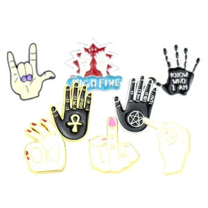 Macro shot of punk rock enamel hand gesture brooches with detailed high-five and ok signs