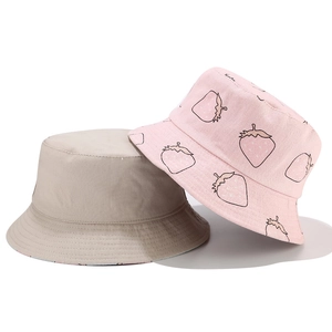 Detailed view of khaki and pink reversible cotton bucket hats with strawberry prints