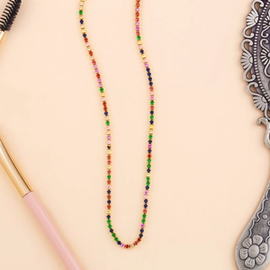 Macro shot of gold-plated tennis necklace with colorful zircons on pink background