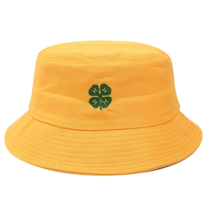 Close-up of green four-leaf clover embroidery with H letters on yellow cotton bucket hat