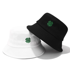 Detailed embroidery of a green clover with H letter on cotton bucket hats in black and white