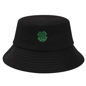 Detail of green four-leaf clover embroidery on a black cotton twill bucket hat