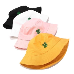 Detail of four colorful bucket hats with four-leaf clover embroidery and letter H detail