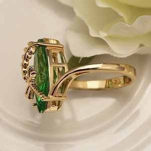 Macro shot of S925 silver stamp and olive green gemstone on golden dragonfly ring