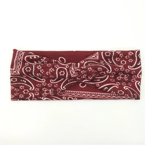 Detailed view of dark red cashew floral knitted yoga headband with elastic twist knot