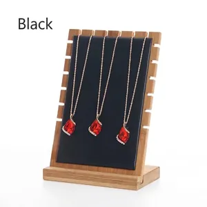 Detail of three teardrop ruby necklaces on a wooden display stand with black padding