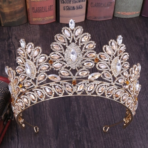 Dettaglio corona da sposa barocca dorata con strass champagne su libri d'epoca