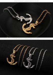 Detailed view of gold and silver anchor necklaces with rope twist chain on black surface