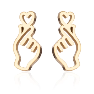 Detail of gold heart-shaped hand gesture earrings with a reflective finish and sleek design