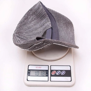 Dettaglio ravvicinato di un cappellino grigio su una bilancia che indica un peso di 101,8g