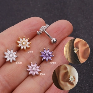 Detail view of flower-shaped stud earrings in gold, silver, purple, and pink with zircon
