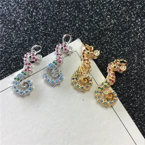 Detail of seahorse pendants with colorful zircons in gold and silver finishes