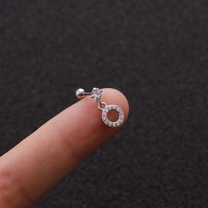 Macro view of silver stainless steel cartilage stud earring with cubic zirconia on finger