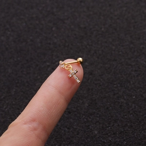 Close-up of golden stainless steel cross earring with micro-set zircon and screw back