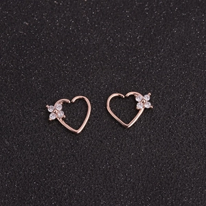 Detail of rose gold heart earrings featuring four delicate cubic zirconia in flower pattern