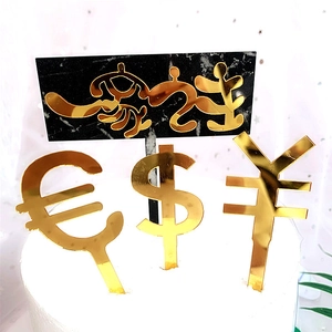 Macro view of golden currency symbols and marble-style acrylic cake toppers for party decor