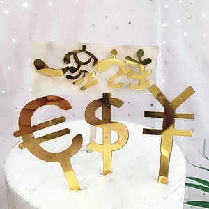 Detail of golden mirror acrylic cake toppers with currency symbols and artistic typography