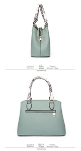 Detail view of light green tote with plaid handle and gold-tone rear zipper pocket