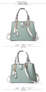 Detail view of bean green PU leather handbag with plaid handles and heart charm
