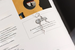 Detailed view of S925 sterling silver long snake drop earrings on a magazine background