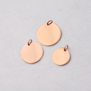 Macro view of three rose gold mirrored stainless steel round pendants with jump rings