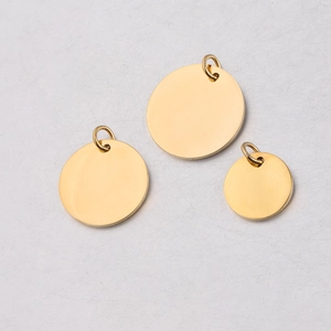Macro view of three polished gold stainless steel circular pendants with hanging loops