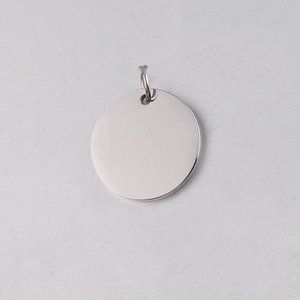 Macro shot of silver stainless steel round pendant with a hanging ring for custom engraving