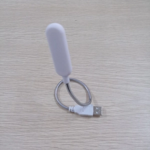 Detail of portable USB LED night light with flexible metal neck on wooden surface
